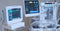 Multiple medical devices display patient diagnostics in a clean, modern medical office or hospital setting.