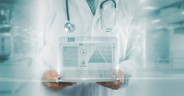 A healthcare professional holds a tablet displaying an EHR interface while wearing a stethoscope in a medical facility.