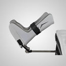 G Stirrups leg positioning device attached to an examination table, showing the adjustable strap and angled positioning for patient support during medical procedures.